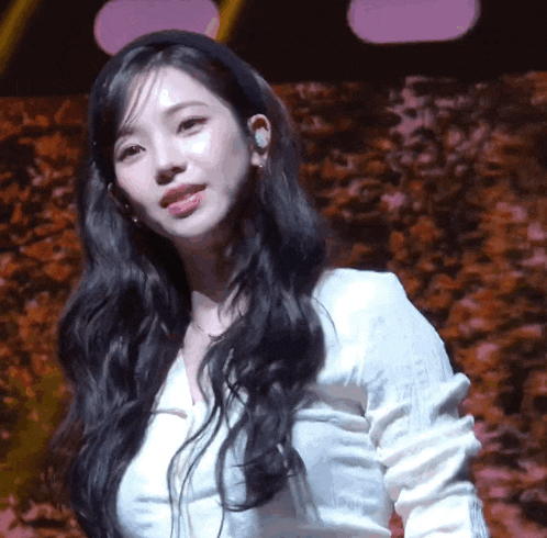 a woman with long black hair wearing a headband and a white shirt