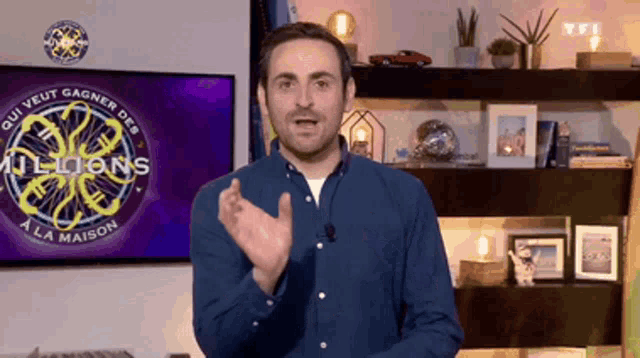 a man is standing in front of a tv screen that says millions