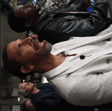 a man in a white suit has a microphone in his neck