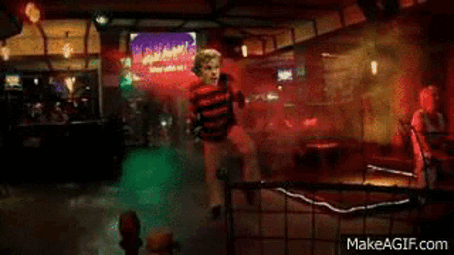 a man is dancing in a dark room with smoke coming out of the ceiling .
