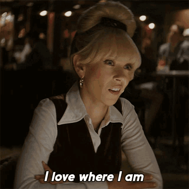 a woman says " i love where i am " with her arms crossed