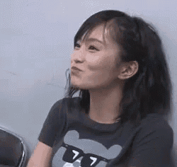 a woman wearing sunglasses and a t-shirt with a bear on it is sitting in a chair .