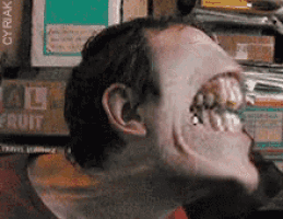 a close up of a man 's face with a stack of fruit boxes in the background