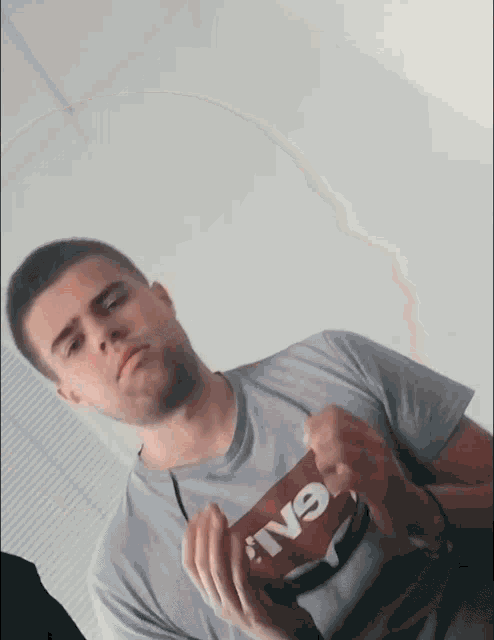 a man wearing a t-shirt that says ' iv9 ' on it holds something in his hands