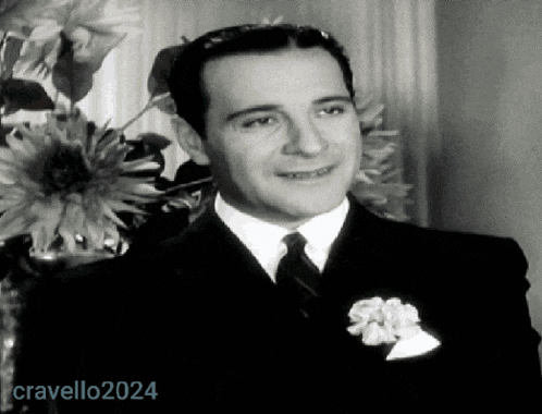 a man in a suit and tie is standing in front of a vase of flowers with the year 2024 on the bottom right