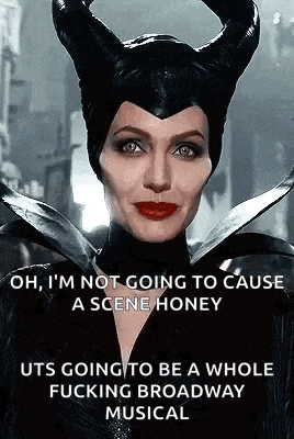 a woman in a maleficent costume with horns is standing in front of a city street .