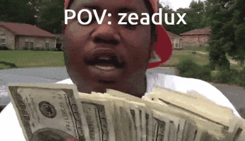 a man in a red hat is holding a stack of money with the caption " pov zeaduk "