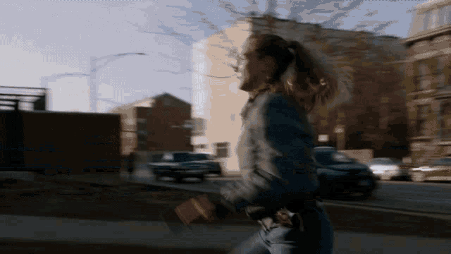 a woman in a ponytail walking down a street