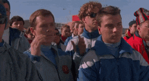 a group of people wearing red jackets and hats are clapping and applauding .