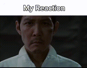 a man in a white shirt is looking at the camera with the words `` my reaction '' written on the bottom .