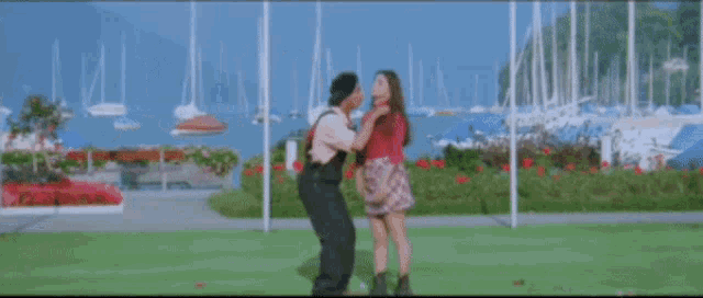 a man and a woman are standing next to each other in front of a body of water .