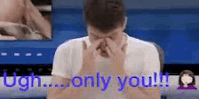 a man is covering his face with his hands and the words `` only you '' are visible behind him .