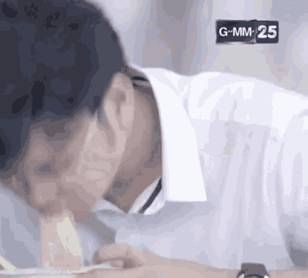 a man in a white shirt is eating a piece of food .