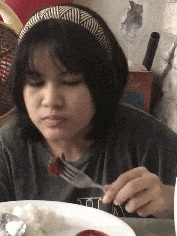 a girl wearing a headband is eating a piece of food