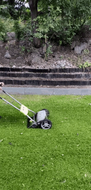 a person is using a lawn mower to mow the grass
