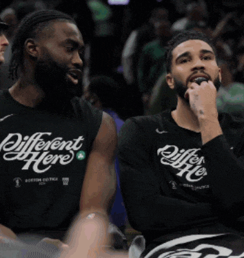 two men wearing black shirts that say different here