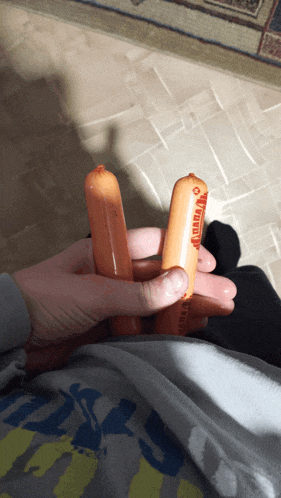 a person is holding two hot dogs in their hands and one of them has the word canada on it