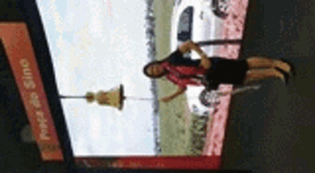 a woman is standing in front of a large screen with a picture of a car .