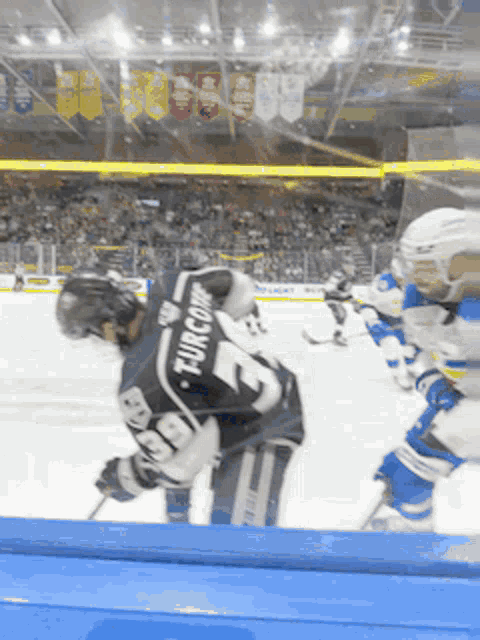 a hockey player wearing a number 19 jersey is being chased by another player