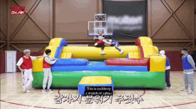a group of young men are playing a game of basketball on a colorful inflatable hoop