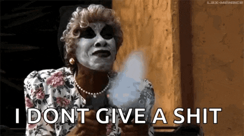 a woman in a mask is holding cotton candy and saying i dont give a shit .