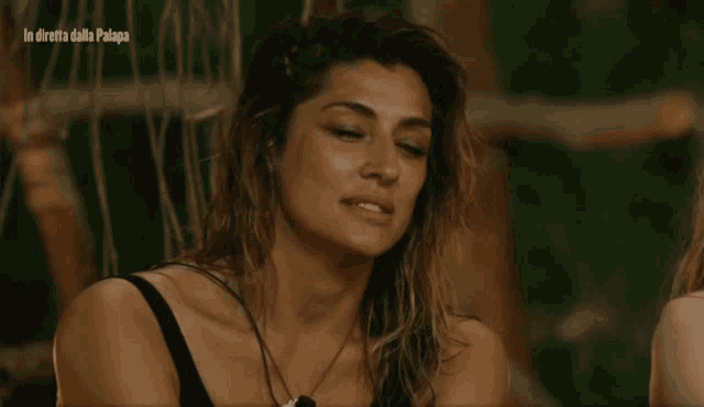 a close up of a woman 's face with the words in diretta dalla palapa behind her