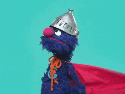 elmo from sesame street is wearing a knight 's armor and a cape .