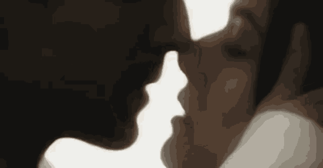 a man and a woman are kissing each other on the nose .