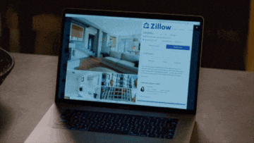 a laptop is open to a page that says ' zillow ' on it