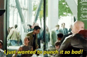 a man is sitting at a table in front of a crowd of people and saying `` i just wanted to punch it so bad ''