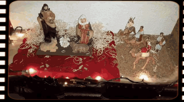 a picture of a nativity scene with figurines on a red cloth