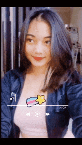 a girl is taking a selfie with a play button on the bottom right