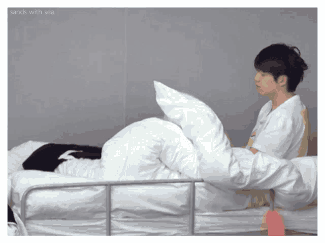 a person laying on a bed with the words sands with sea written above them