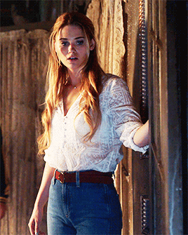 a woman in a white shirt and blue jeans