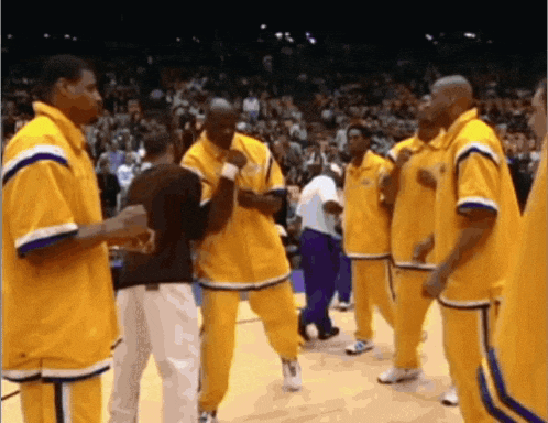 a group of basketball players in yellow uniforms are standing on the court