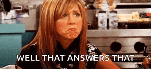 a woman is making a funny face and saying `` well that answers that '' while sitting in front of a stove .