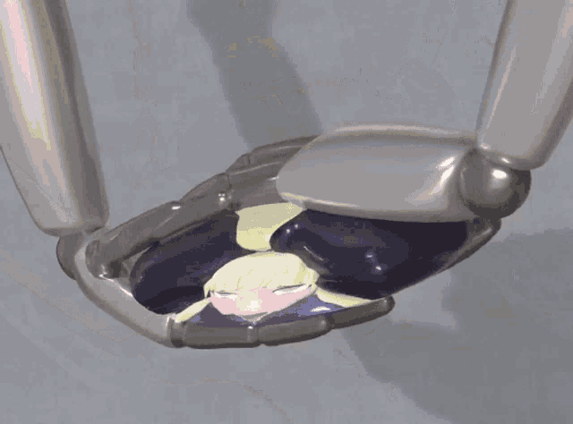 a robotic hand is holding a cartoon character with a sad face