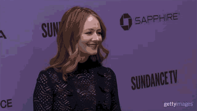 a woman is smiling in front of a sundance tv poster