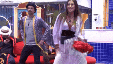 a woman in a white dress is dancing with a man in a blue jacket in front of a sign that says bandisoft.com