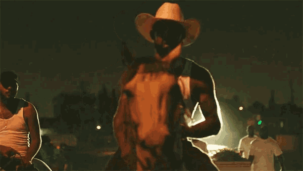 a man in a cowboy hat rides a horse