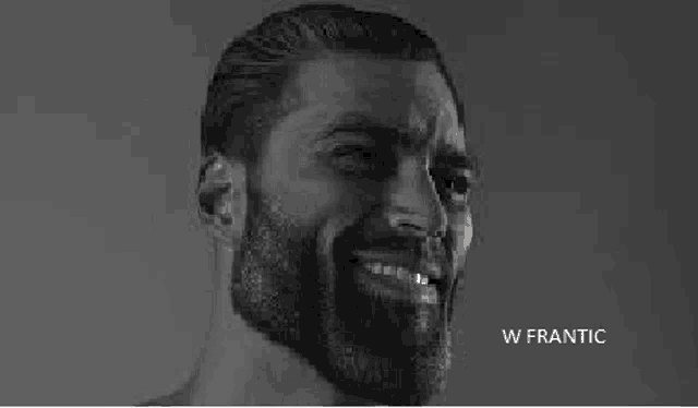 a black and white photo of a man with a beard smiling and making a face .