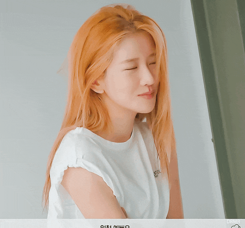a woman wearing a white t-shirt with the word en on it smiles