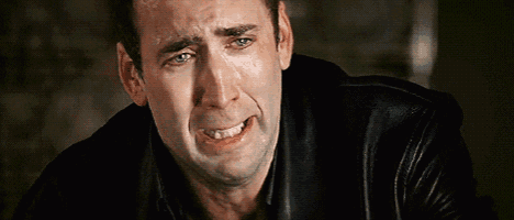 a man in a black leather jacket is crying with his eyes closed .