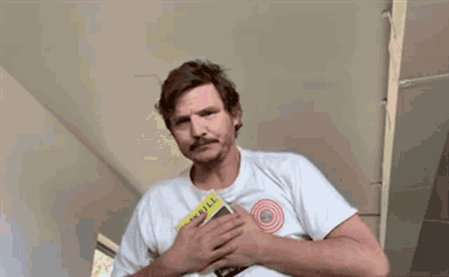 a man with a mustache is wearing a white t-shirt and holding a cigarette in his pocket .