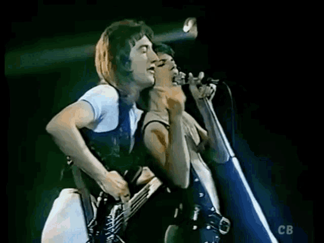 a man and a woman are singing into microphones on stage .