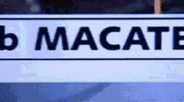 a white sign with black letters that says macate