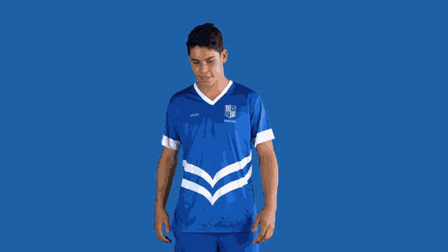 a man wearing a blue shirt that says ' ucsd ' on it stands in front of a blue background
