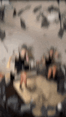 a blurry picture of people sitting around a table in a room
