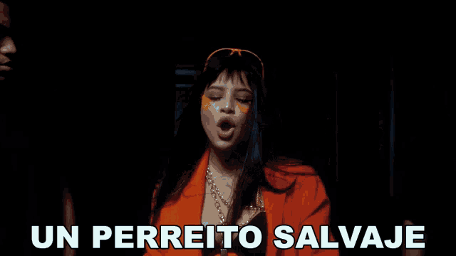 a woman in an orange jacket is standing in front of a sign that says un perreito salvaje