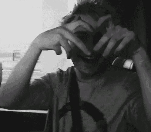 a black and white photo of a person making a peace sign